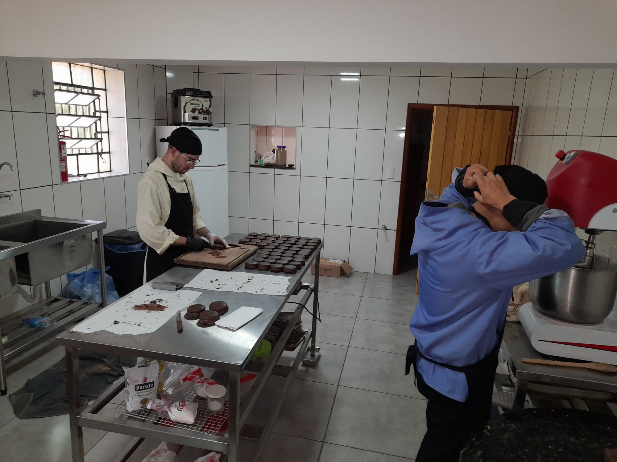 Monges trabalhando na cozinha de produção